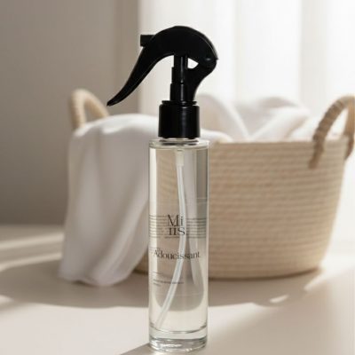 Flacon spray Adoucissant dans un décor doux et minimaliste avec du coton.